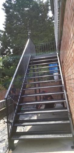 open tread diamond plate steel stairs with support columns and half inch picket railings, all fully welded.